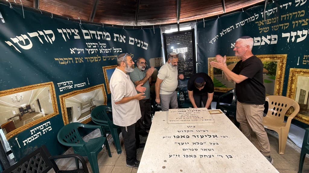 קבוצת מבקרים סביב מצבת הצדיק בשירה ותפילה