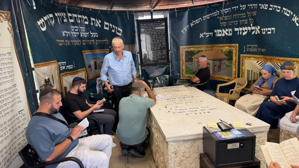 מבקרים בתפילה סביב מצבת רבי אליעזר פאפו